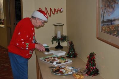 Resident decorating a holiday cookie table