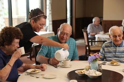 Residents enjoying a meal with staff service