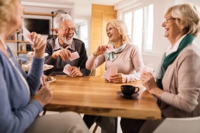 Residents enjoying a game and laughter in the lounge