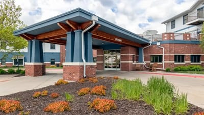 Entrance of a senior living facility with gardens