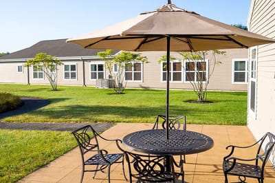 Outdoor seating area with patio umbrella and landscaping