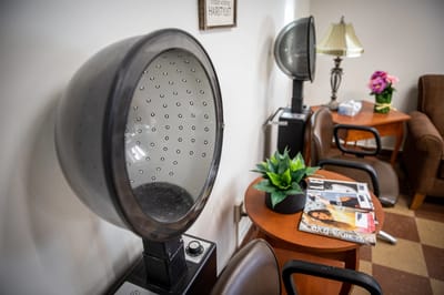 Interior salon area with hair dryers and seating