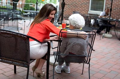 A caregiver and elderly resident sharing a moment outdoors