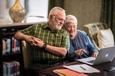 Senior couple using a laptop in a cozy room