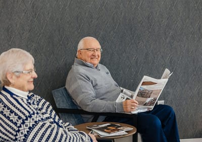 Residents reading newspapers in a common area