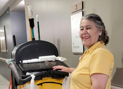 Staff member holding cleaning equipment in a hallway