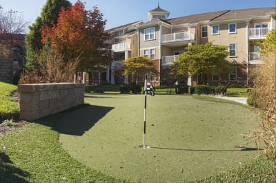 Outdoor area with a putting green and building in background