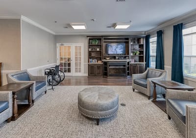 Common area with seating and TV in a senior living facility
