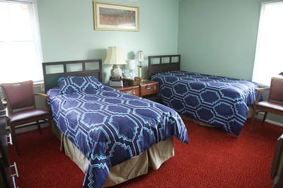A shared resident room with two beds and bedside tables