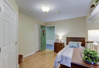 A well-furnished resident room with a bed and decor
