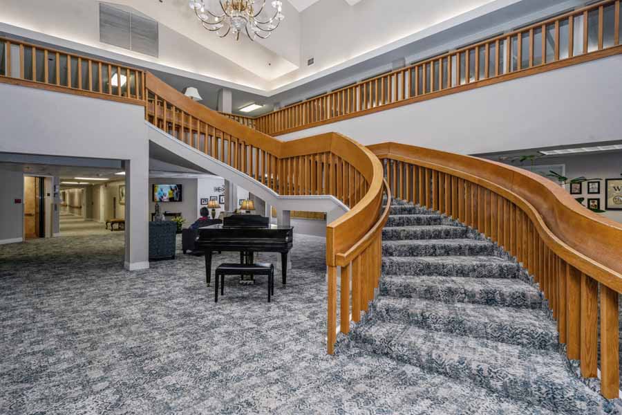 Interior view of a lobby with a piano and staircase
