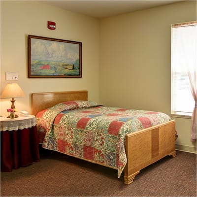 Cozy bedroom with colorful quilt and bedside lamp