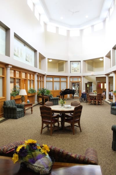 Common area with seating and piano in a senior living facility