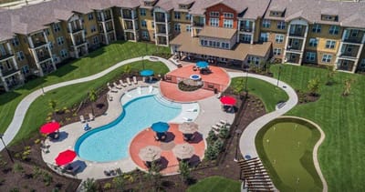 Aerial view of a senior living facility with a pool and outdoor seating