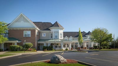 Exterior view of a senior living facility showing gardens and entrance