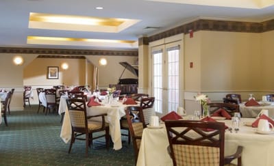 Elegant dining room setup with piano in background