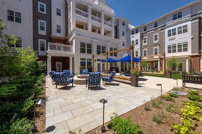 Outdoor seating area with gardens and building in background