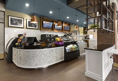 Brightly lit coffee shop area with seating and display cases