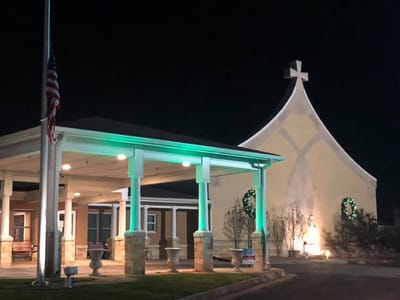 Exterior view of Carmel Home at night with decorations