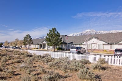 Exterior view of a senior living facility with mountains
