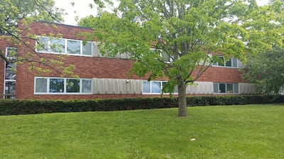Exterior view of a red brick building surrounded by grass
