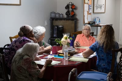 Residents engaging in conversation around a table