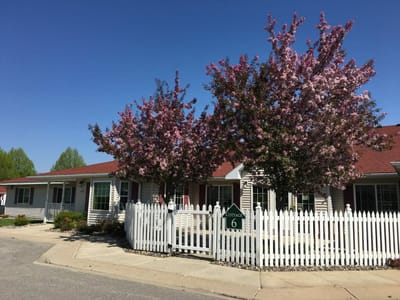 Exterior view of Cottagewood Senior Community with flowering trees