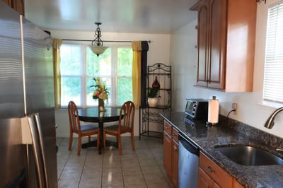 A well-lit kitchen area with a dining table and flowers