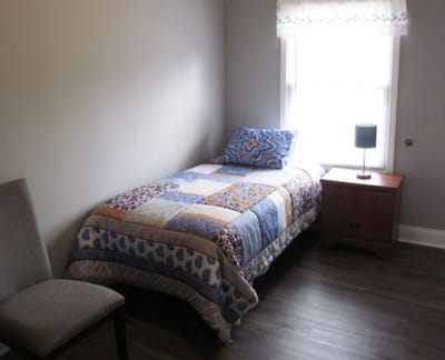 Cozy private room with a bed and side table