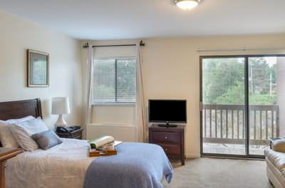 A cozy resident room with a bed and TV.