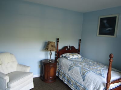 Cozy private resident room with a bed and armchair