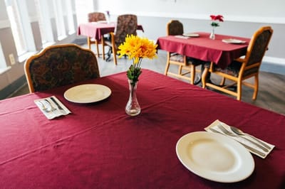 Dining room setup with tables and flowers