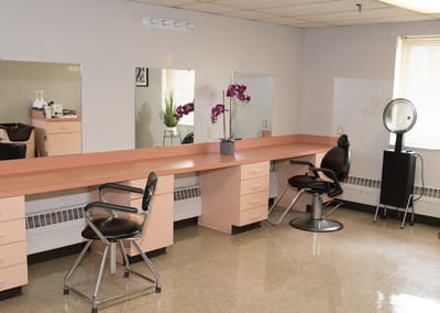 Bright salon area with two styling chairs and mirrors