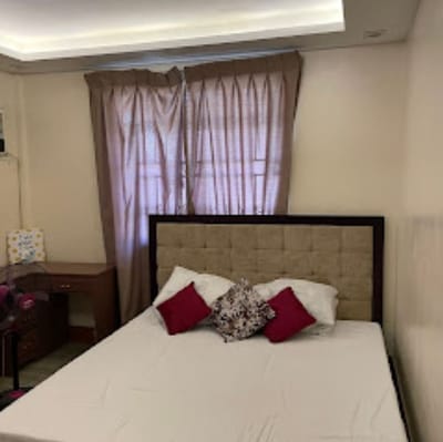 A well-furnished private resident room with a bed and curtains