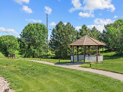 Pathway leading to a gazebo in a green landscape
