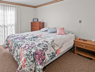 Cozy bedroom with floral bedding and wooden furniture