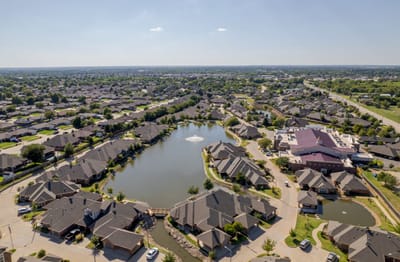 Aerial view of a senior living community with a pond