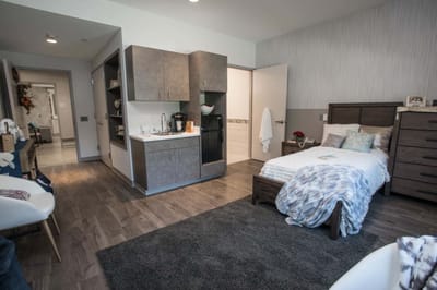 A private resident room showing a bed and kitchenette