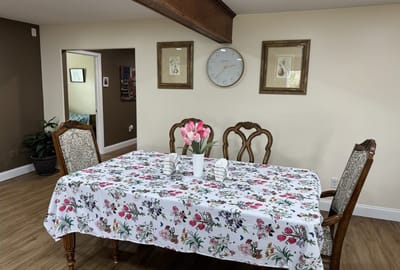Dining area with flower centerpiece and patterned tablecloth