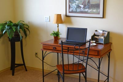 Cozy corner in a senior living unit with a desk and lamp