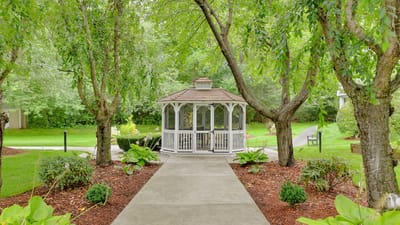A gazebo surrounded by trees in a landscaped garden