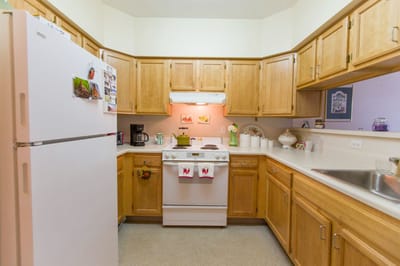 A kitchenette with wooden cabinets and appliances