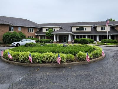 Front entrance of a senior living facility with flags