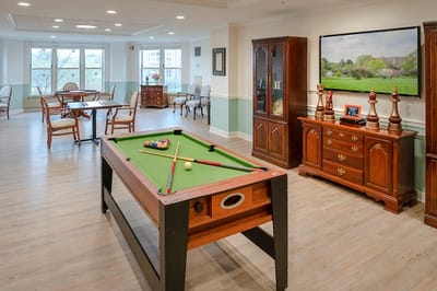 A game room with a pool table and seating area