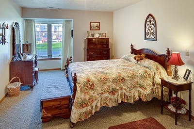 Cozy resident bedroom with floral decor and wood furniture