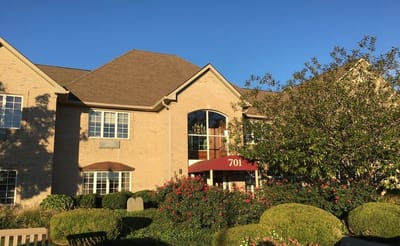 Exterior view of a senior living facility with landscaped gardens