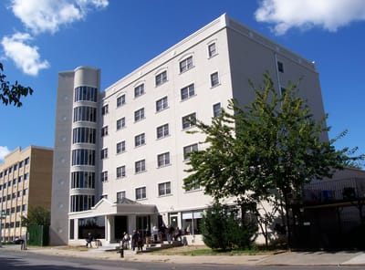 Exterior view of a senior living facility with residents outside