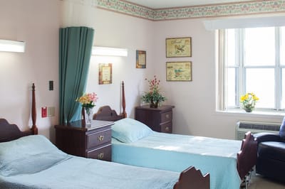 A shared resident room with two beds and decorations