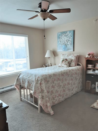 Cozy resident bedroom with floral decor and natural light