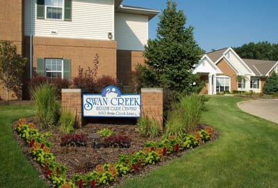 Exterior view of Swan Creek Health Care Center sign and landscaping